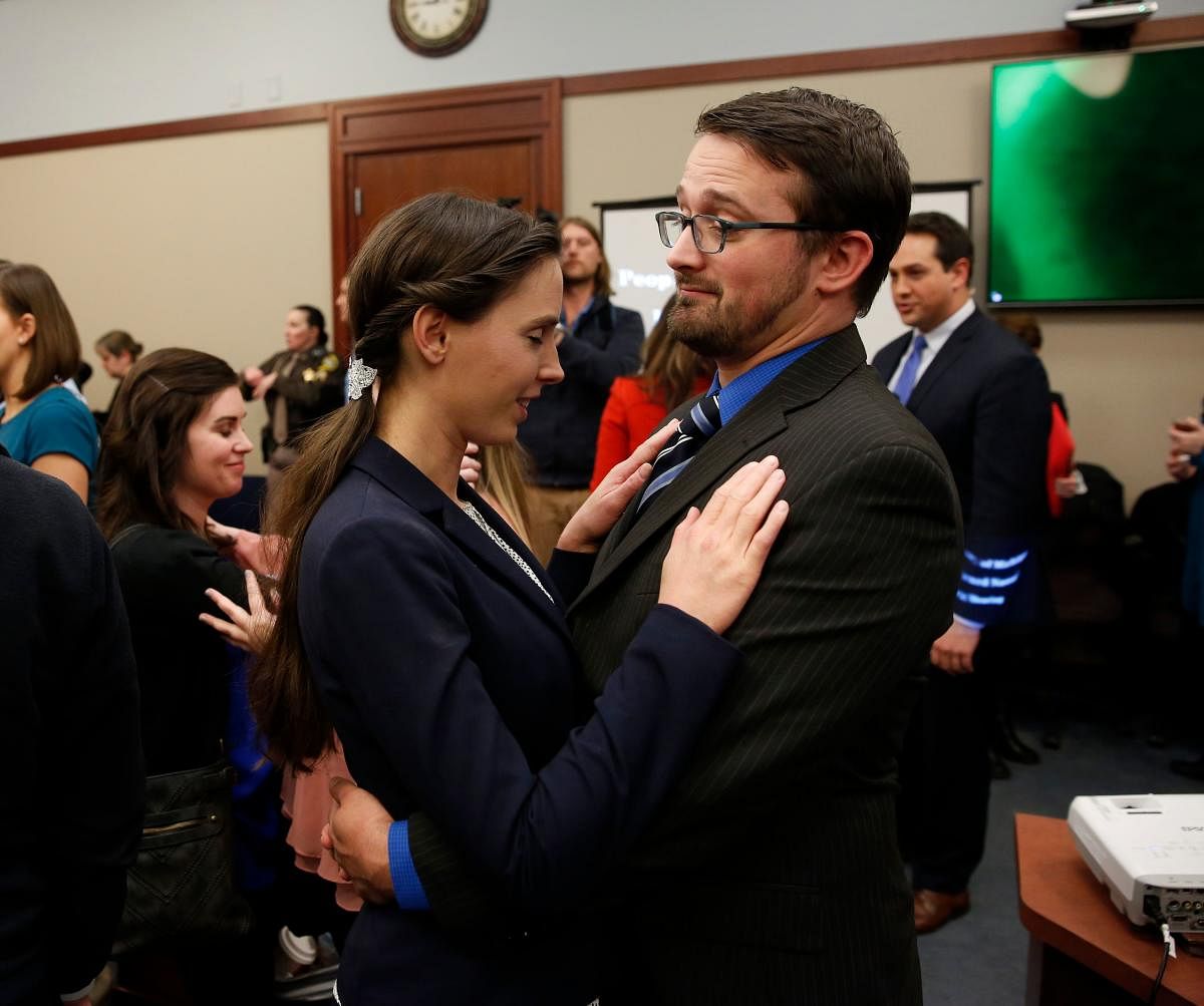 Tough times: Rachael Denhollander who was victimized by former Former Michigan State University and USA Gymnastics doctor Larry Nassar is consoled by her husband Jacob after Nassar was sentenced to 40 to 175 years in prison on Wednesday. AFP
