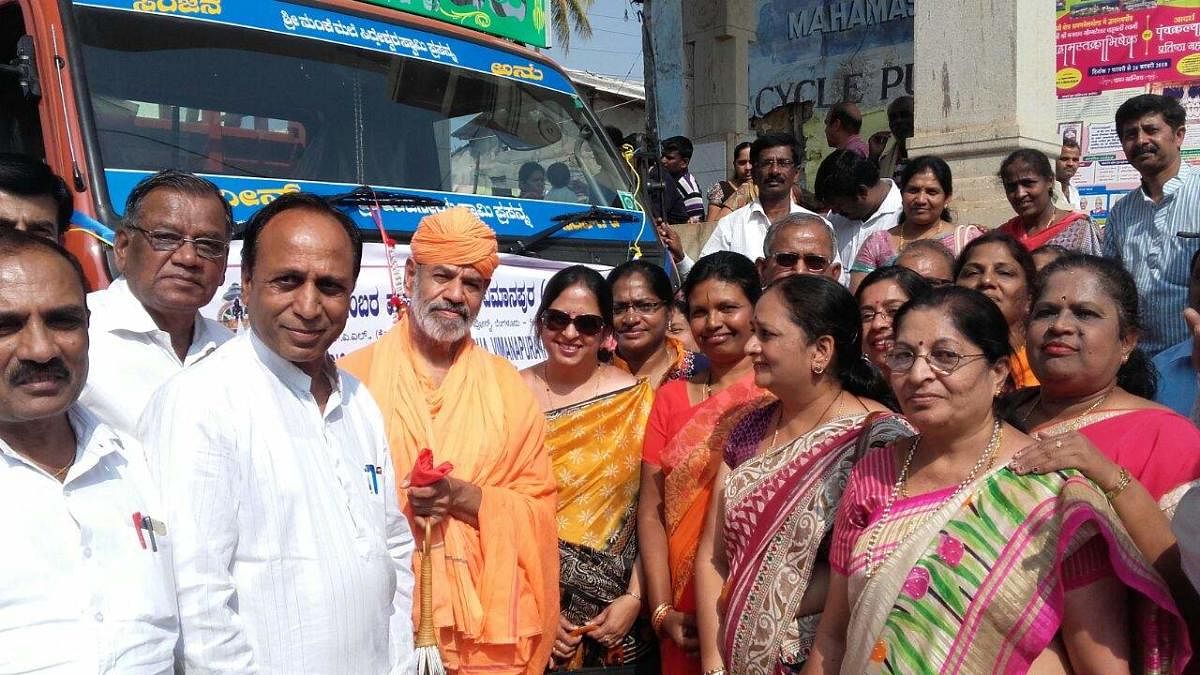 Jain Mutt seer Charukeerthi Bhattaraka Swami receives the trucks carrying foodgrains donated by devotees at Shravanabelagola in Hassan district on Tuesday. dh photo