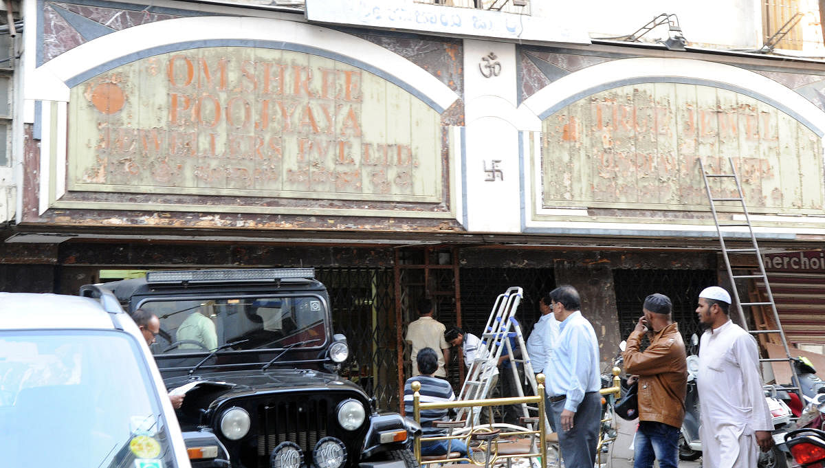 One of the jewellery shop name being taken off at Sringar Complex at MG road as they were vecating due to the court order in Bengaluru on Tuesday. Photo Srikanta Sharma R.