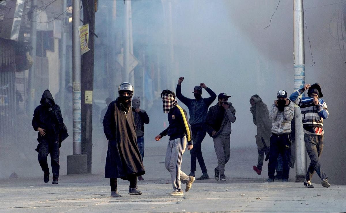 Protesters throw stones on security forces amid tear smoke during a protest against the killing of two youths in army firing in Shopian district of south Kashmir, in Srinagar. PTI