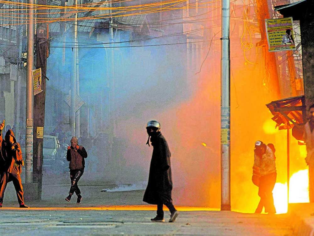 A teargas shell explodes near the protesters who were clashing with security forces following a protest against the alleged killing of two youth Army firing in Shopian district of South Kashmir, in Srinagar on Sunday. PTI Photo