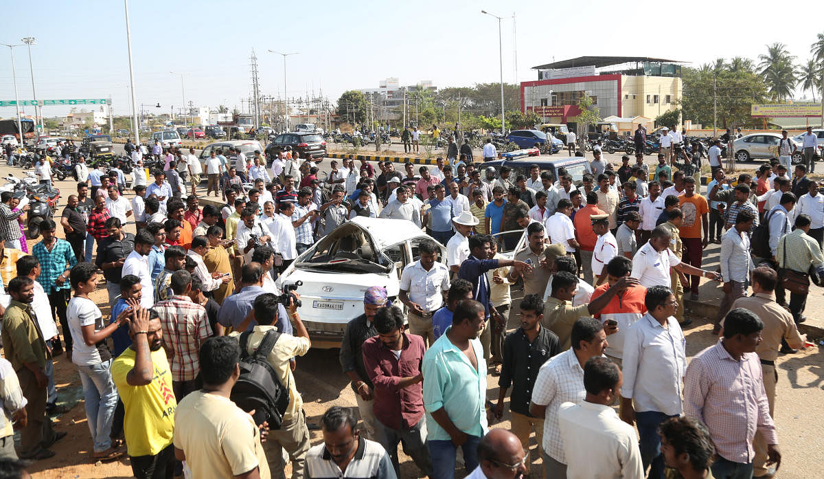People look at the car which met with an accident, killing three students, on the Ring Road at Dattagalli in Mysuru on Wednesday. DH PHOTO
