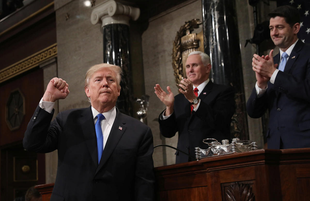 U.S. President Donald J. Trump (L) gestures at the podium in front of U.S. Vice President Mike Pence (L) and Speaker of the House U.S. Rep. Paul Ryan (R-WI) during his first State of the Union address to a joint session of Congress inside the House Chamber on Capitol Hill in Washington, U.S., January 30, 2018. REUTERS/Win McNamee/Pool TPX IMAGES OF THE DAY