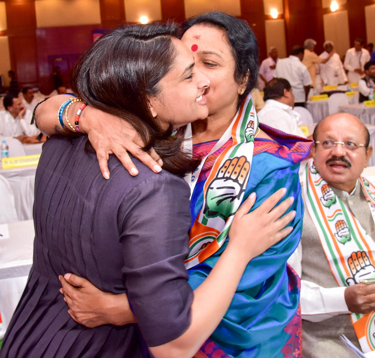 Congress leaders and actors Ramya and Umashree greet each other at the party's campaign committee meeting at a star hotel in Bengaluru on Wednesday. Law Minister T B Jayachandra looks on. DH Photo/ B H Shivakumar