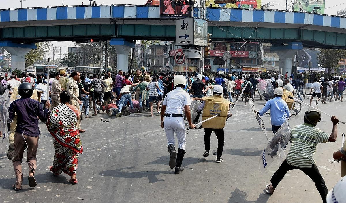 Police cane charge an irate mob that set on fire a bus at Chingrighata crossing on EM bypass after a bus reportedly jumped a traffic signal and killed two youths in Kolkata on Saturday. PTI