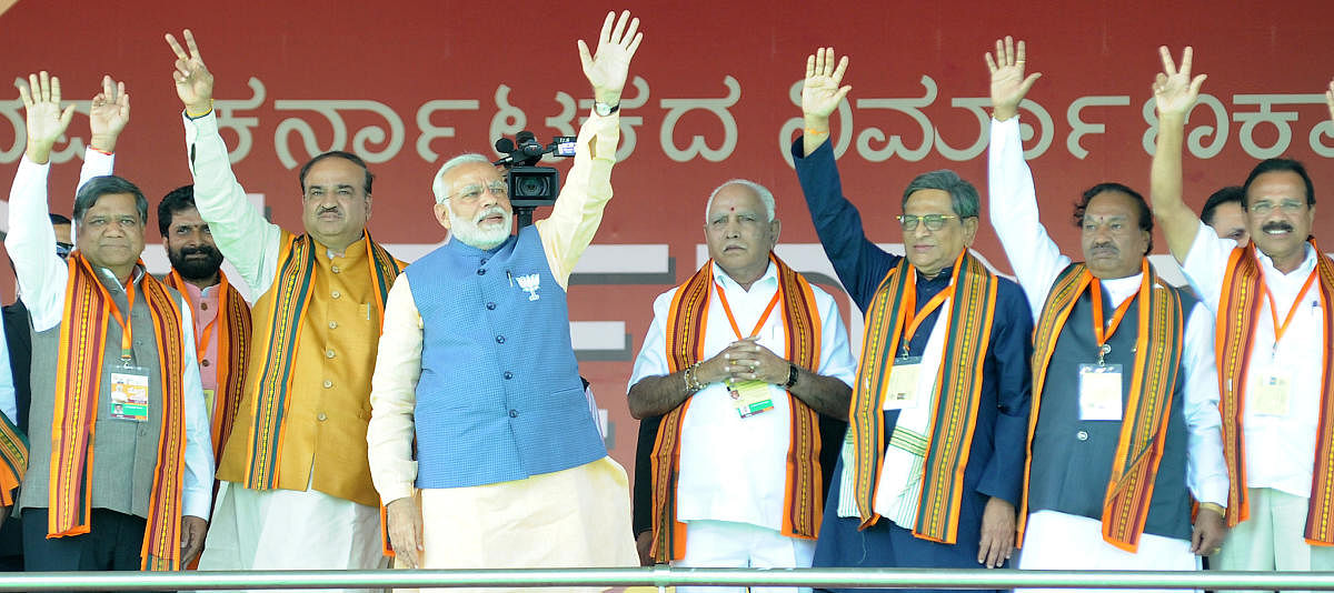 Prime Minister Narendra Modi (fourth from left) waving to the crowd at the BJP rally at Palace Grounds in Bengaluru on Sunday. Also seen are BJP leaders Jagadish Shettar, C T Ravi, Ananth Kumar, B S Yeddyurappa, S M Krishna, K S Eshwarappa and D V sadananda Gowda. Photo Srikanta Sharma R.