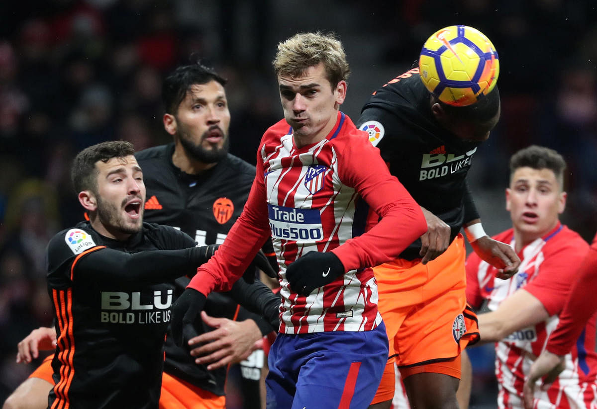 Atletico Madrid's Antoine Griezmann in action with Valencia's Geoffrey Kondogbia and Jose Luis Gaya in the La Liga on Sunday. REUTERS