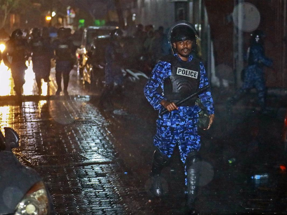 A Maldives policeman charges with baton towards protesters after the government declared a 15-day state of emergency in Male, Maldives, early Tuesday, Feb. 6, 2018. The Maldives government declared a 15-day state of emergency Monday as the political crisis deepened in the Indian Ocean nation amid an increasingly bitter standoff between the president and the Supreme Court. Hours after the emergency was declared, soldiers forced their way into the Supreme Court building, where the judges were believed to be taking shelter, said Ahmed Maloof, an opposition member of Parliament. AP/PTI.