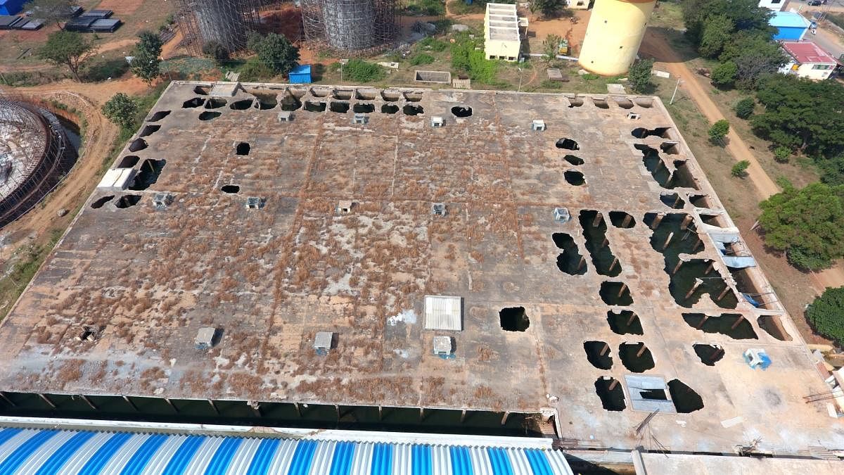 The dilapidated roof of the central storage reservoir, behind the renovated tank, at Vijayanagar, in Mysuru.