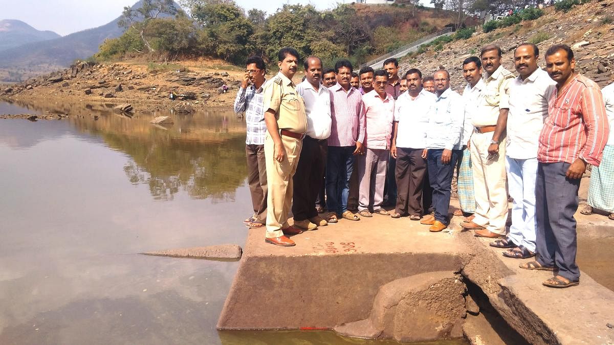 Officials measure the water level at Ayyanakere in Sakharayapattana in Kadur.
