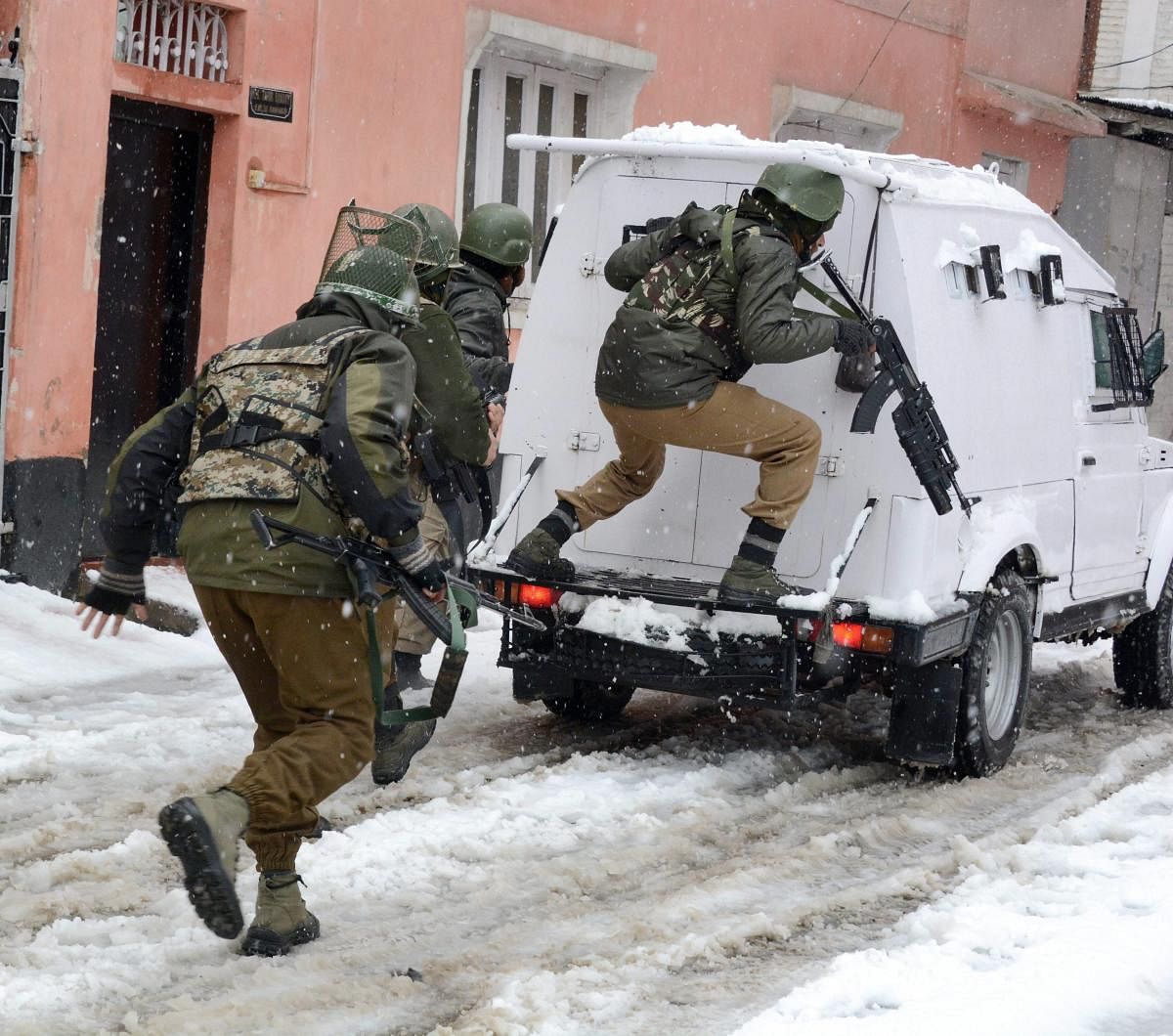 Security personnel take positions during an encounter with the militants who were sheltering in a building near a CRPF camp at Karra Nagar, in Srinagar on Monday. PTI Photo