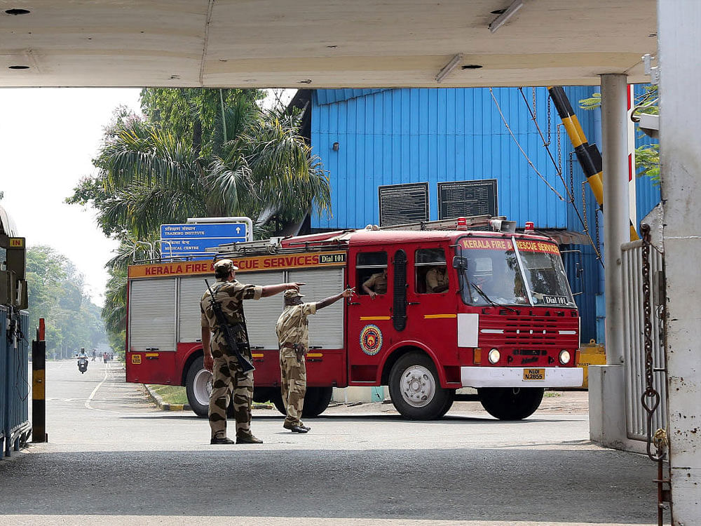 Policemen direct a fire engine after a fire broke out on a ship under repair at the Cochin Shipyard Ltd, in Kochi on Tuesday. REUTERS