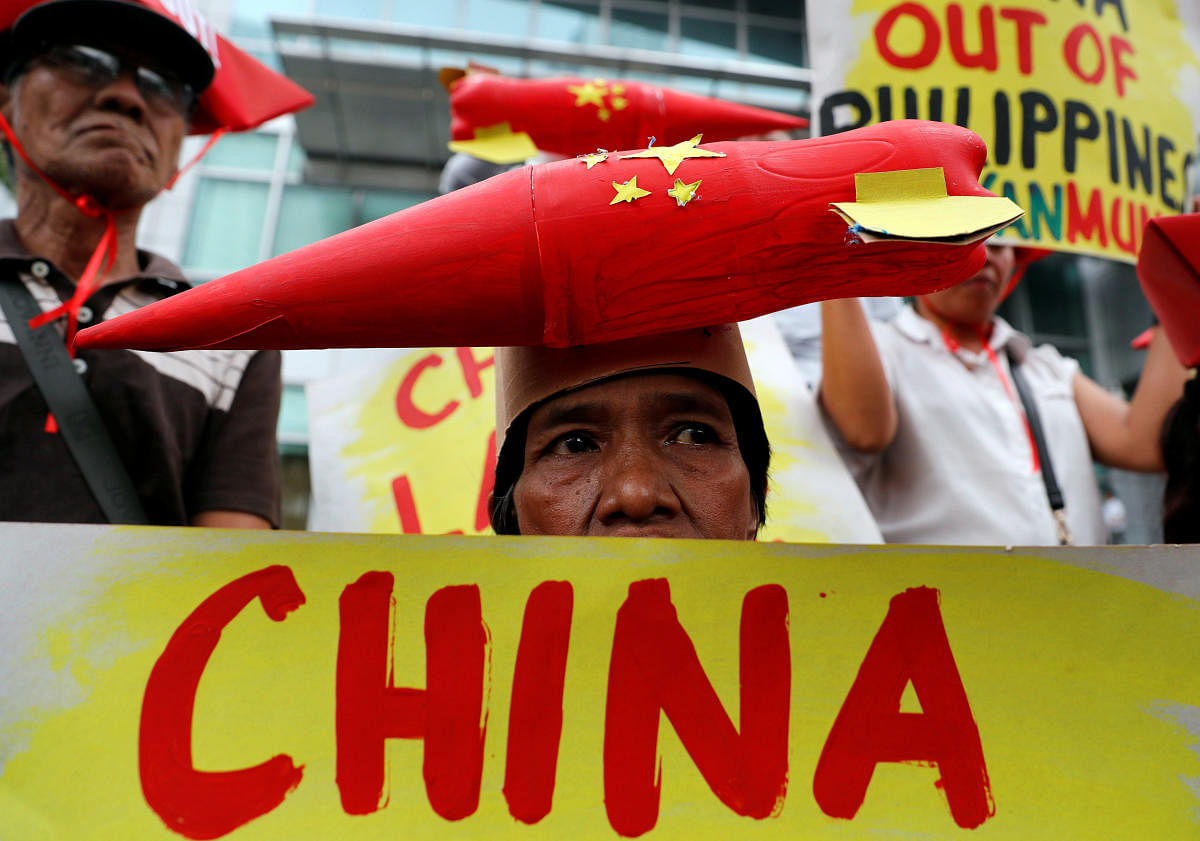 Protestors display placards during a rally by Leftwing activists outside the Chinese Consulate, to protest Beijing's continued reclamation activities in the South China Sea, in Makati, Metro Manila in the Philippines. REUTERS