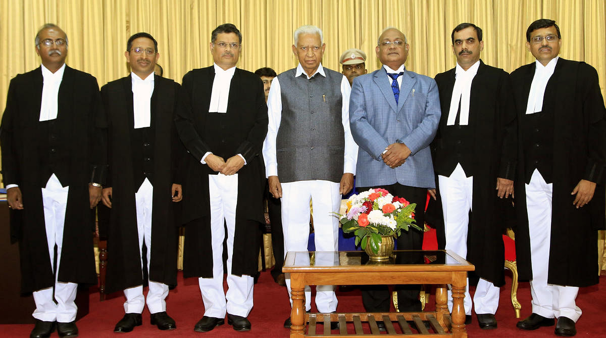Advocates (from left) Siddappa Sunil Dutt Yadav, Bhotanhosuru Mallikharjuna Shyam Prasad, Dixth Krishna Shripad, Shankar Ganapathi Pandit (2nd from right) and Ramakrishna Devadas with governor Vajubhai vala and chief justice of high court of Karnataka Dinesh Maheswari after the swering ceremony in rajbhavan , appointed as additional judges of the Karnataka high court in Bengaluru on Wednesday. DH Photo.