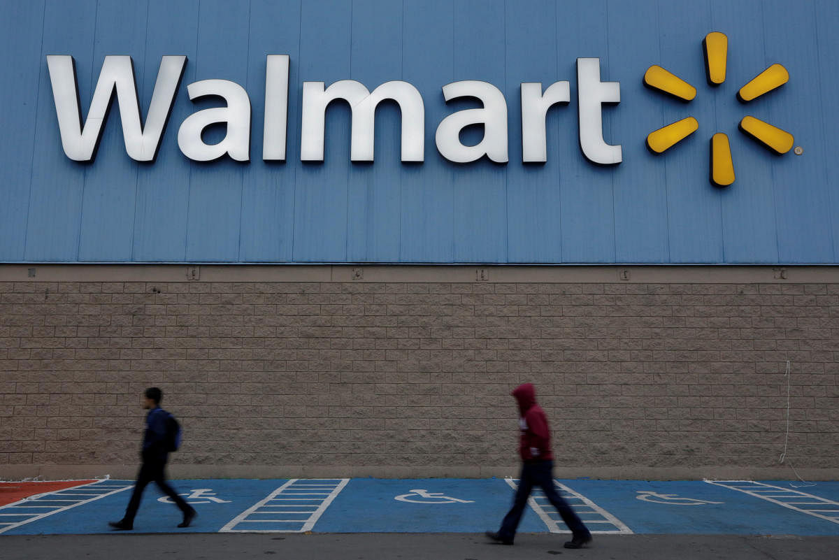 Men walk past the logo of Walmart outside a store in Monterrey, Mexico February 12, 2018. REUTERS