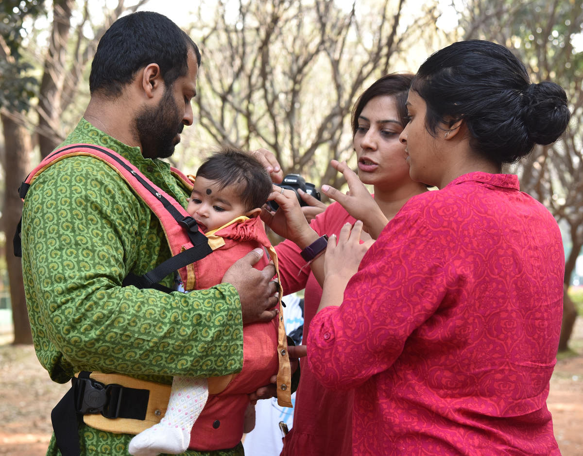 Ridhima Goel, baby carrying educator, helping parent of an infant to use the carrier. DH Photo/S K Dinesh