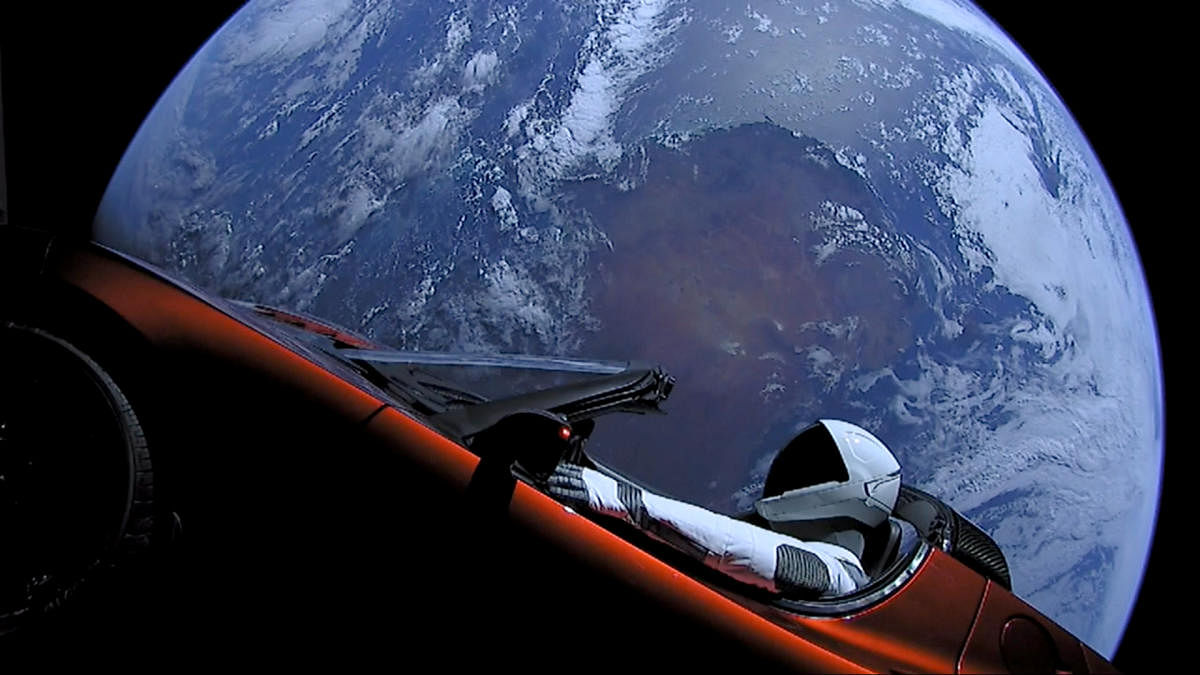 A cherry red Tesla Roadster automobile floats through space after it was carried there by SpaceX's Falcon Heavy. REUTERS
