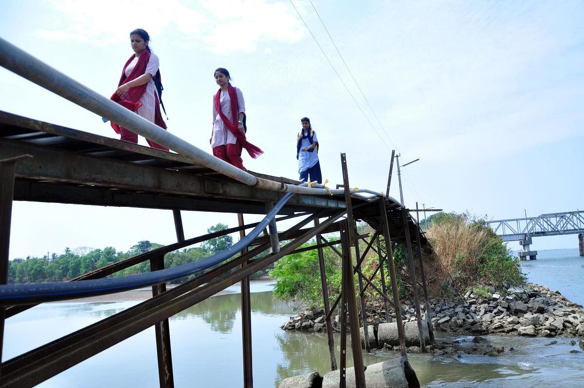 Students cross a footbridge that is in a deplorable condition near the Nethravathi bridge on the outskirts of Mangaluru.