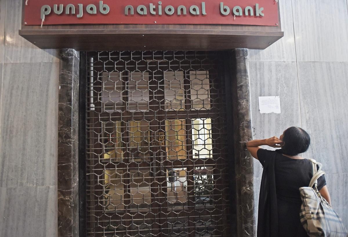 A woman looks on as CBI team seals Punjab National Bank's South Mumbai branch at Brady House in Mumbai on Monday. The PNB fraud case involving jeweller Nirav Modi was allegedly carried out of this branch. PTI Photo by Shashank Parade (PTI2_19_2018_000088B)