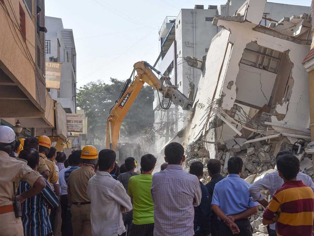 Four workers were killed and 14 sustained injuries after a five-storey building, half of which was under construction, collapsed at Jayaramareddy Layout in Kasuvanahalli. DH Photo