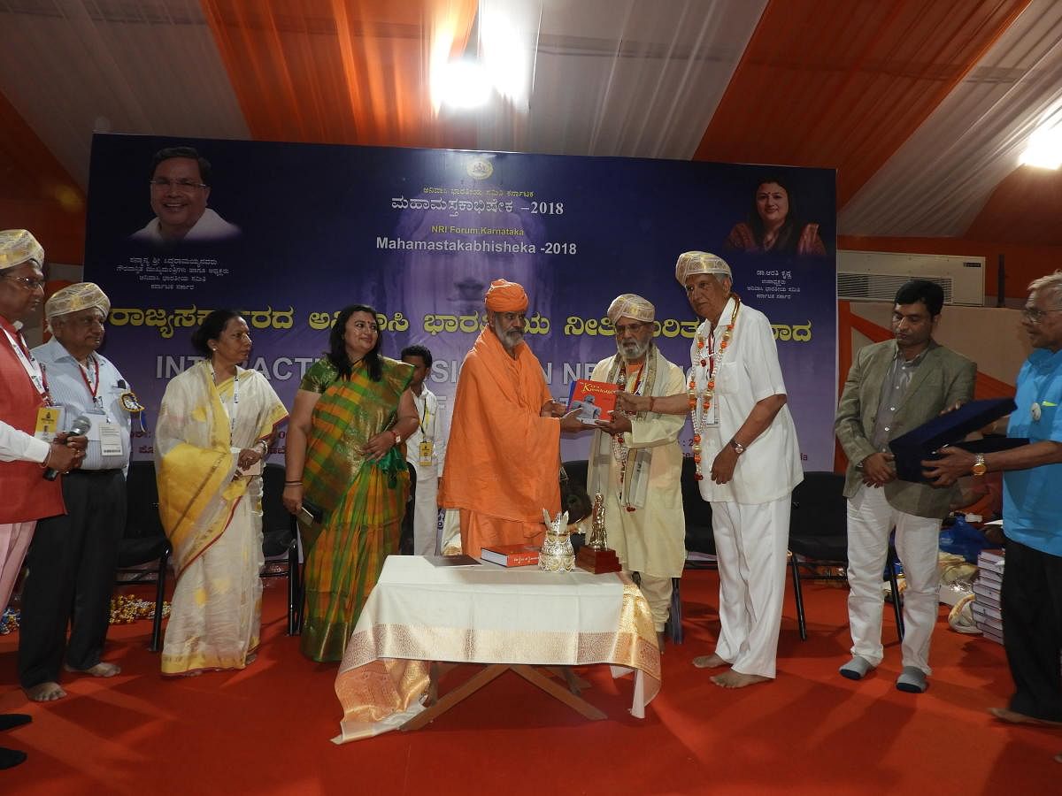 Jain Mutt seer Charukeerthi Bhattaraka Swami felicitates non-resident Indian (NRI) participants at Shravanabelagola, Hassan district, on Thursday. dh photo