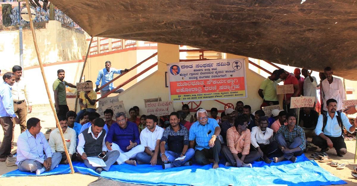 Devarapura Paisari colony residents stage a protest at Gandhi Maidan in Madikeri on Friday.