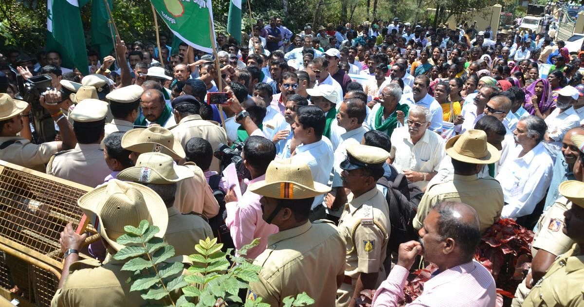 Farmers and members of the Karnataka Rajya Raitha Sangha and the Karmikara Aranya Horata Samithi stage a protest in front of Aranya Bhavana in Madikeri on Friday.