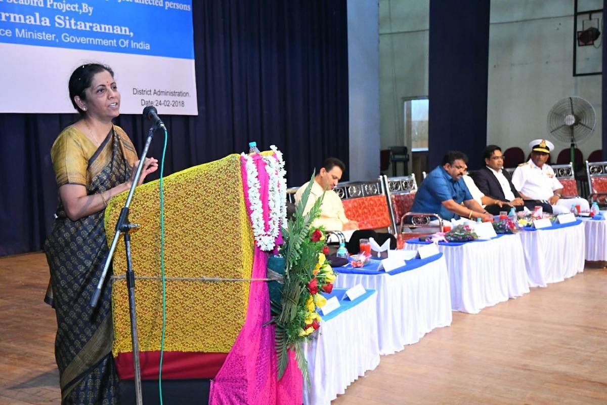 Defence Minister Nirmala Sitharaman speaks at a function held to distribute compensation to the displaced families of Seabird project, in Karwar on Saturday. Union minister Anantkumar Hegde is also seen. DH PHOTO