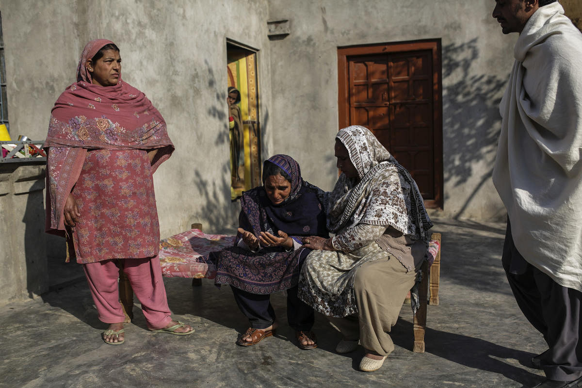 Village women console Nusrat Bibi, center, whose son Mazhar Hussain died trying to migrate to Italy, in Gujrat, Pakistan, Feb. 8, 2018. Hussain and a cousin paid $13,000 - a fortune, even for the well-to-do here, to a smuggler guaranteeing safe passage to Europe; a boat he was on capsized in the Mediterranean. (Sara Farid/The New York Times)