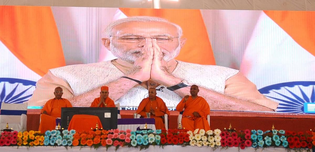 Prime Minister Narendra Modi greets the gathering before his address at the valedictory of the silver jubilee of the Ramakrishna Vivekananda Ashram in Tumakuru, through video-conferencing from New Delhi, on Sunday. dh photo