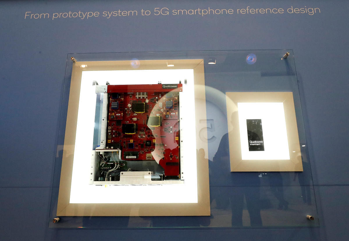 A display in the booth of Qualcomm shows the journey early 5G phone chipsets have made out of the lab, starting as a suitcase full of outsized prototype components (L), which has now been shrunk into a smartphone the size of a very thick chocolate bar (R), at Mobile World Congress in Barcelona February 27, 2018. Pictures taken February 27, 2018. REUTERS/Yves Herman