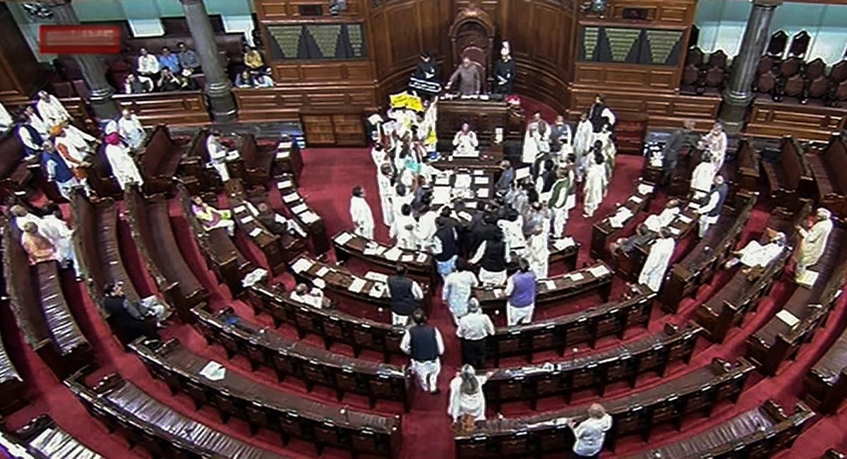 Opposition members protest during the budget session of Parliament in the Rajya Sabha in New Delhi on Monday. PTI