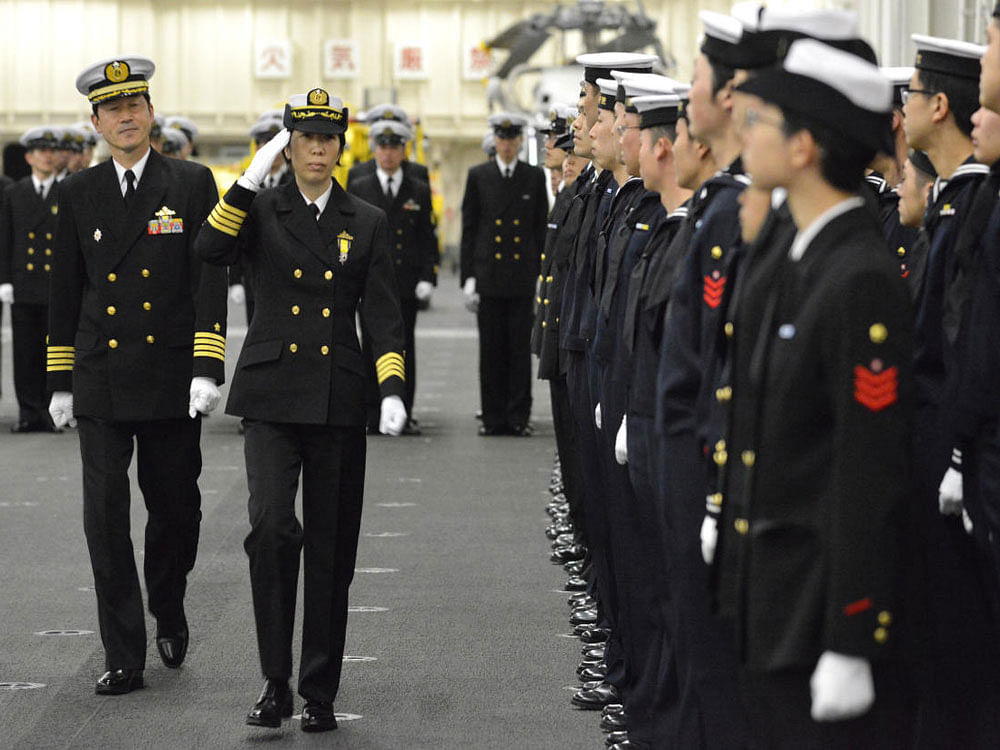 Newly-appointed Commander of First Escort Division of Japan Maritime Self-Defense Force (JMSDF) Ryoko Azuma (2nd L), who is the first female commander of a navy destroyer squadron in Japan, salutes to soldiers on JMSDF's helicopter carrier Izumo at a port in Yokohama, south of Tokyo, Japan. Reuters Photo