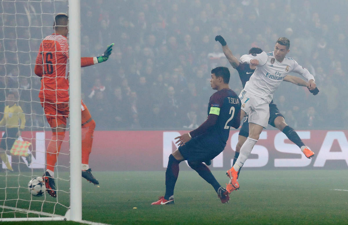 ON TARGET: Real Madrid's Cristiano Ronaldo (right) heads home his side's first goal against PSG on Tuesday. Reuters