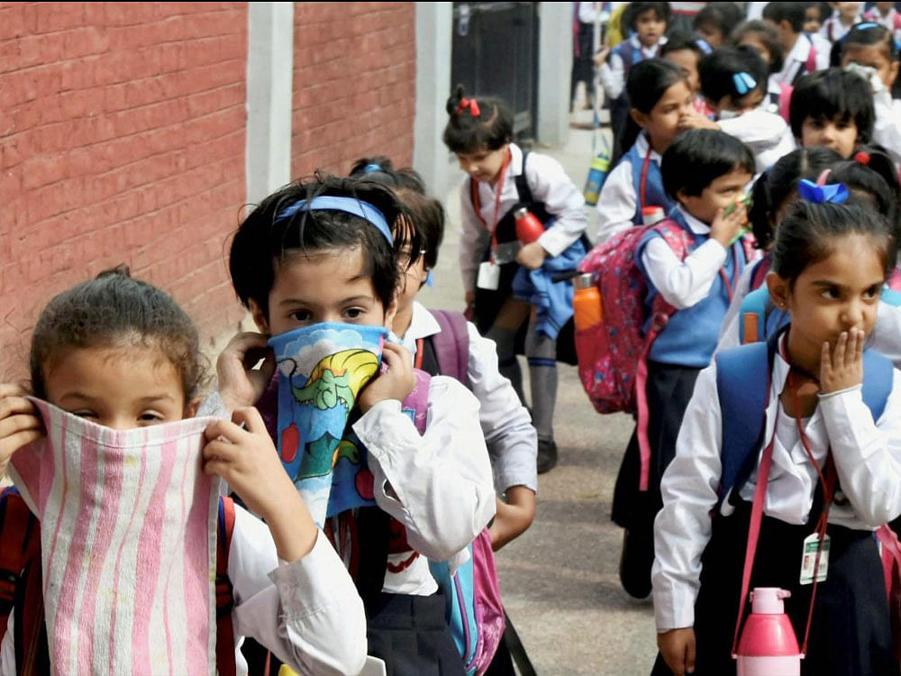 School children cover their noses as air pollution reached hazardous levels in New Delhi on November 7, 2017. PTI.