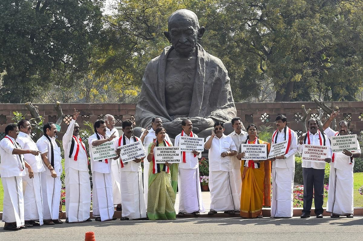 iNew Delhi: AIDMK MP's protest in front of Mahatma Gandhi's statue at Parliament House demanding creation of Cauvery Water Management Board during the second phase of the budget session in New Delhi on Friday. PTI Photo by Kamal Singh(PTI3_9_2018_000064B)