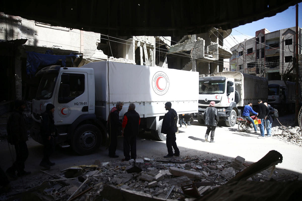 People are seen around Red Crescent aid truck in the besieged town of Douma, Eastern Ghouta in Damascus, Syria, on Friday. REUTERS