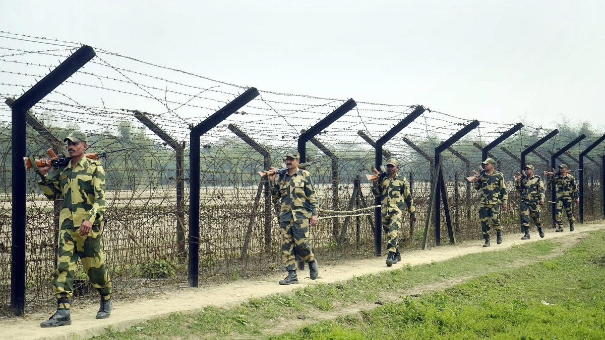 Indian Border Security Force (BSF) personnel patrol along the India-Bangladesh border ahead of Prime Minister Narendra Modi's 2nd phase of his political rally ahead of assembly elections at Ragna village in Dharmanagar. PTI Photo