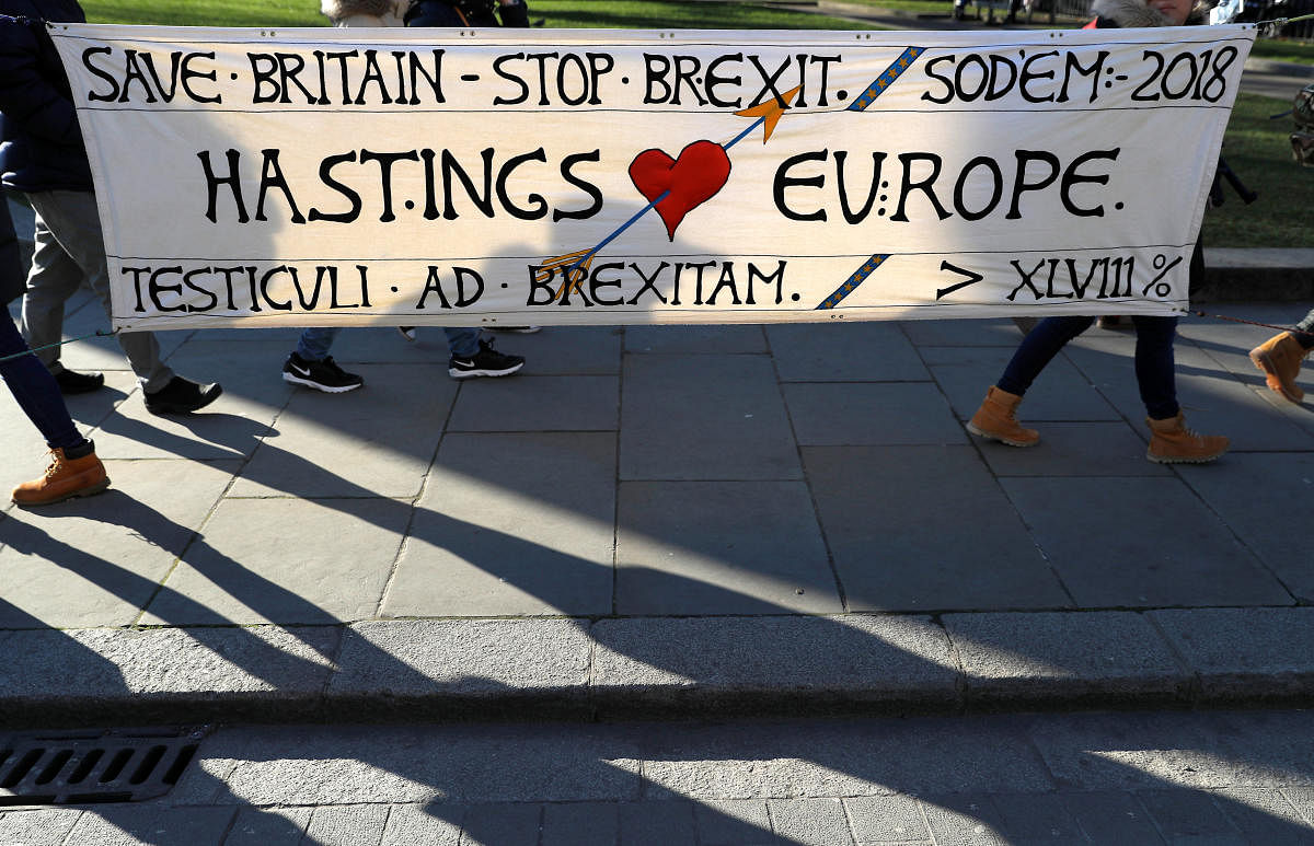 Tourists walk past an anti-Brexit banner displayed opposite the Palace of Westminster in London, Britain. REUTERS