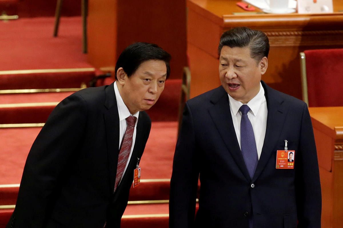 Chinese President Xi Jinping speaks with Chinese Politburo Standing Committee member Li Zhanshu at the third plenary session of the National People's Congress (NPC) at the Great Hall of the People in Beijing. Reuters Photo