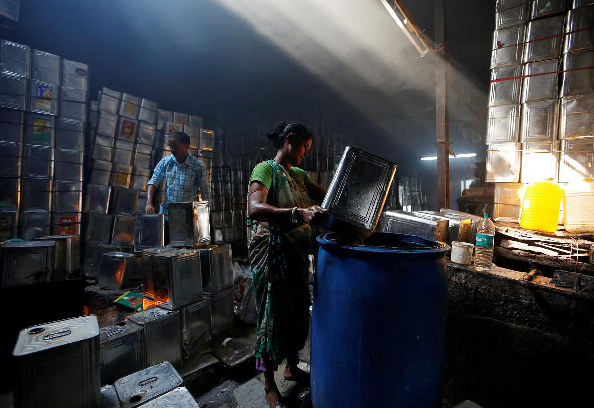 A woman cleans used cooking oil tins in a recycling workshop in Mumbai. Reuters file photo