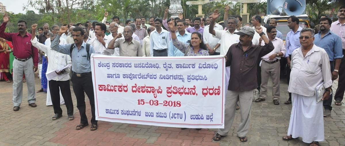Members of Jilla Karmika Sanghatanegala Janti Samithi stage a protest in Udupi on Thursday.