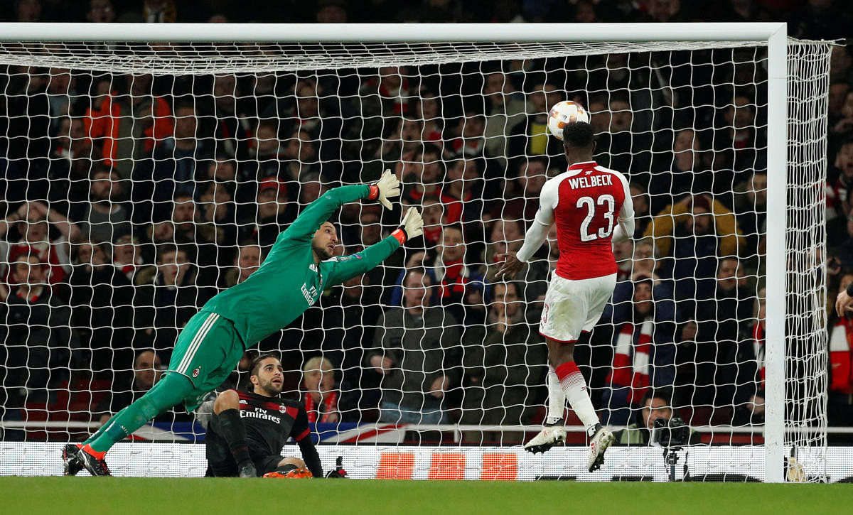 NO STOPPING THAT! Arsenal's Danny Welbeck (right) heads past a valiant AC Milan keeper Gianluigi Donnarumma during their Europa League last 16 clash on Thursday. Reuters