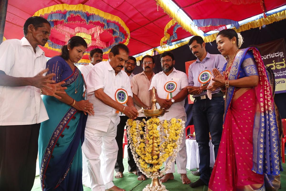 Belthangady MLA Vasanth Bangera lights a lamp to inaugurate 'Maneyangaladalli Kannada Kalarava' programme in Belthangady.