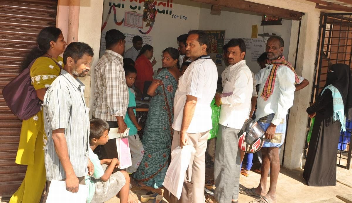 People queue up to get the corrections rectified in their Aadhaar cards at a private service centre in Subhash Nagar in Mandya.