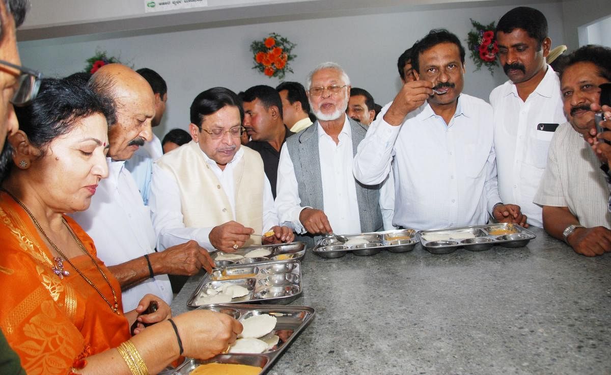 District In-charge Minister M R Seetharam and others have food at the new Indira Canteen on Race Course Road in Madikeri on Thursday.