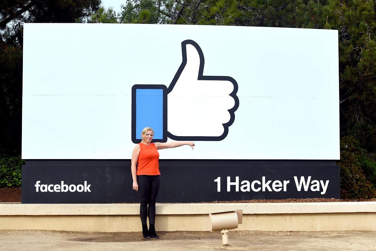 A woman makes a thumbs down sign in front of Facebook's corporate headquarters in Menlo Park, California on March 21, 2018. Facebook chief Mark Zuckerberg vowed on March 21 to