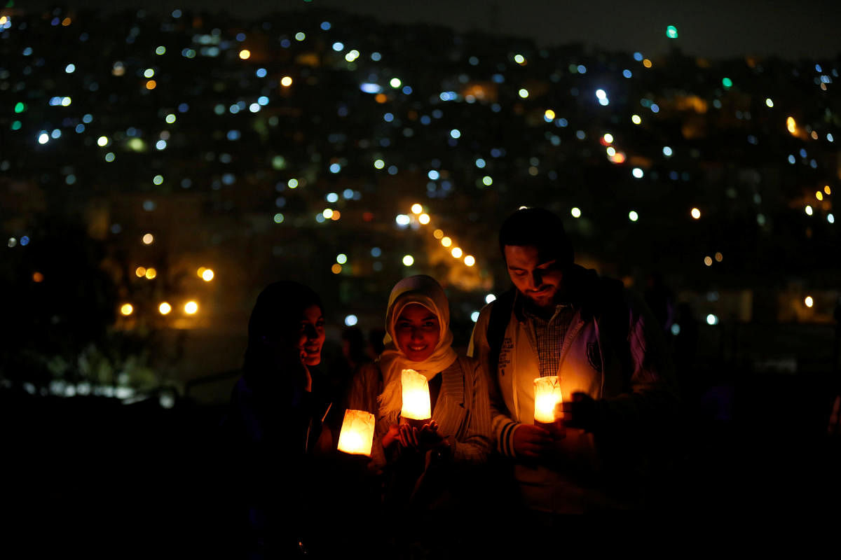 People hold candles as they gather at Amman Citadel, an ancient Roman landmark, to mark Earth Hour in Amman, Jordan March 24, 2018. REUTERS