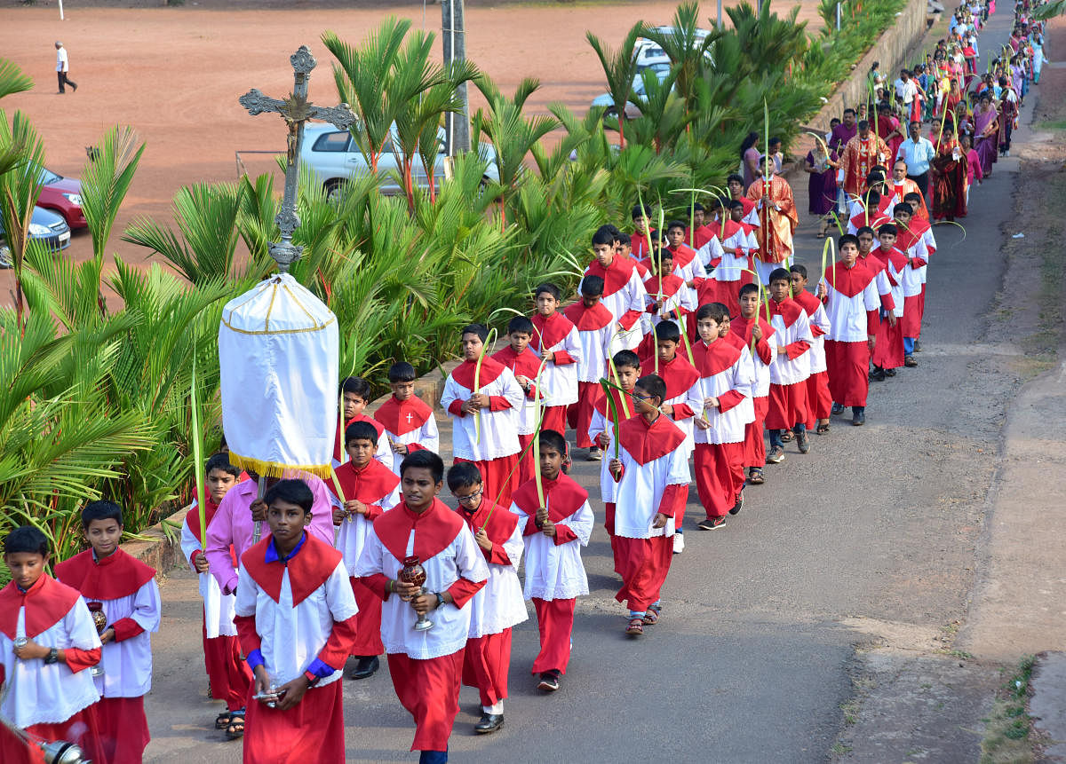 Parishioners with palm leaves take out a procession to church, as a part of Palm Sunday celebrations at Holy Cross Church in Kulshekar on Sunday. DH PHOTO