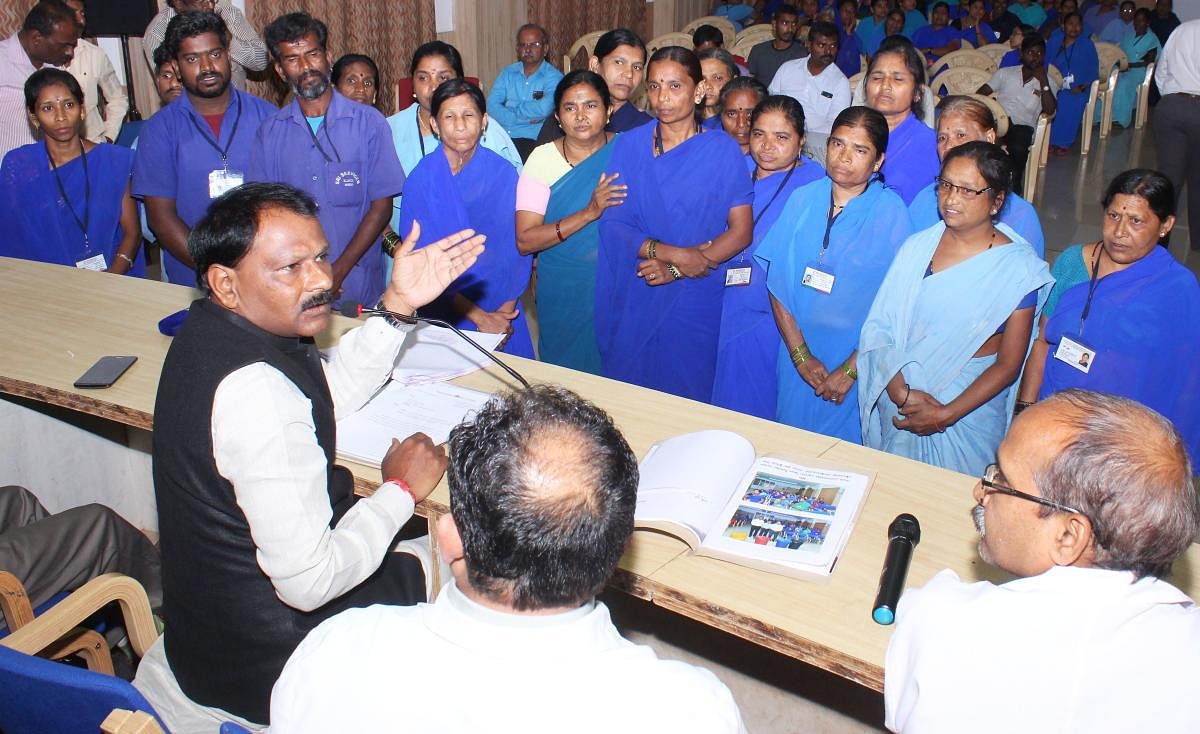 National Safai Karmachari Commission member Jagadish Hiremani interacts with contract cleaning workers, at KIMS in Hubballi on Monday.